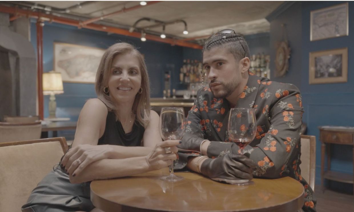 Two people sitting at a table drinking wine.