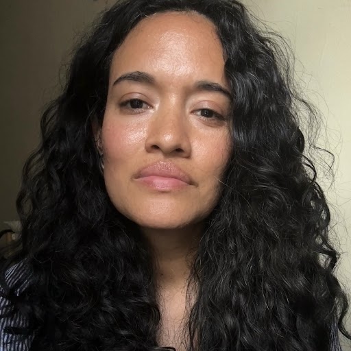 headshot of a woman with long, dark, wavy hair