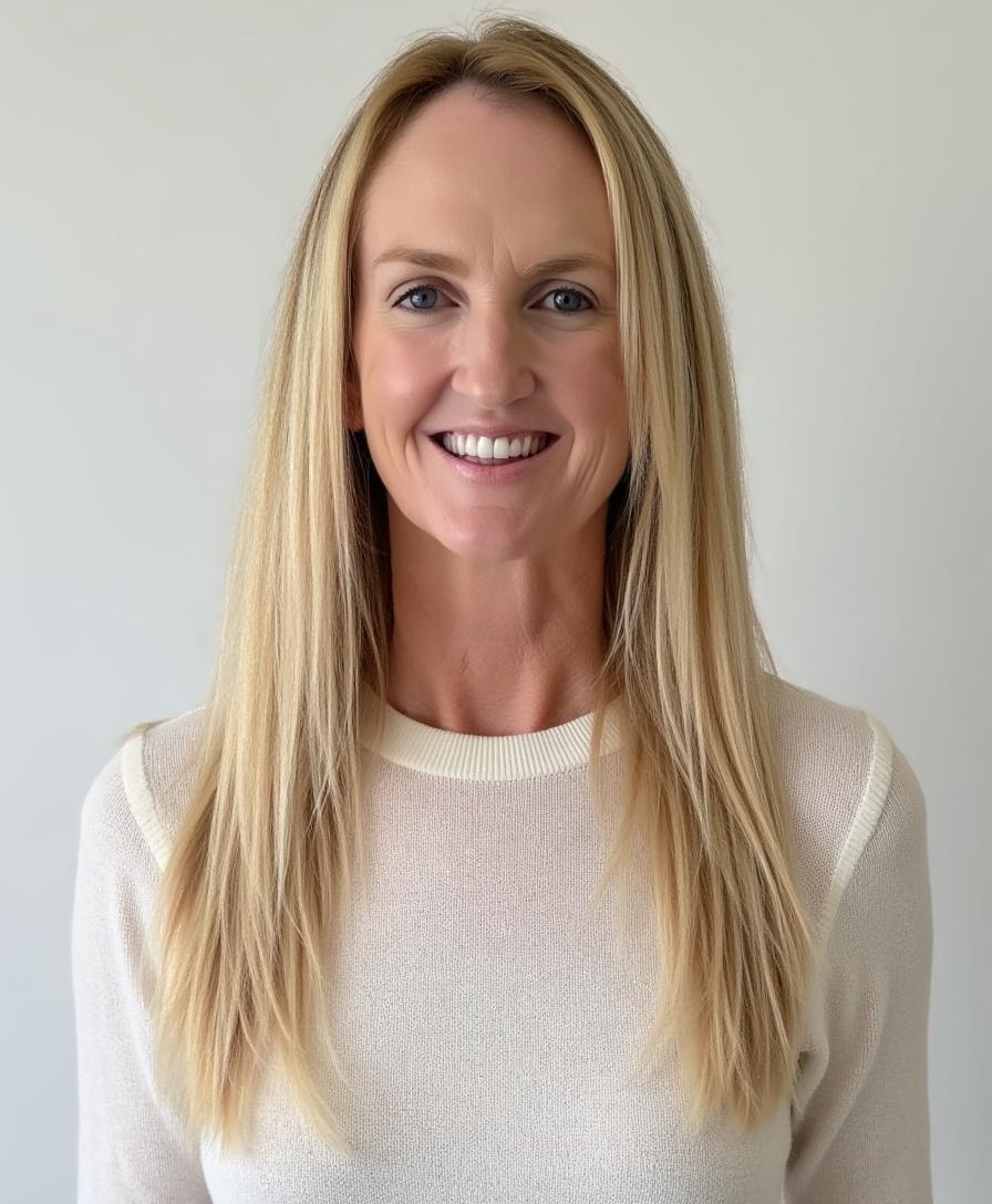 headshot of a white, blonde woman in a white blouse in front of a white background