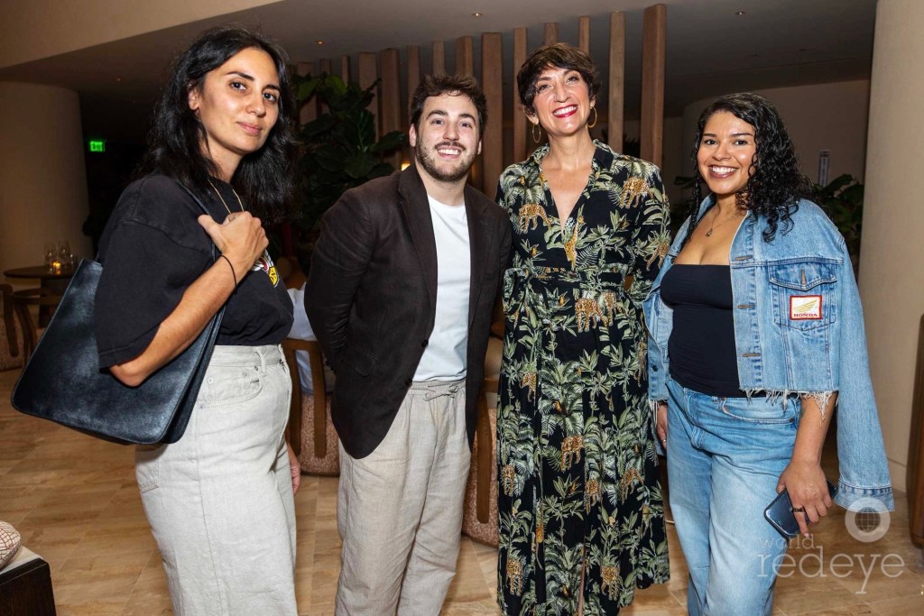 four people pose in a hotel lobby