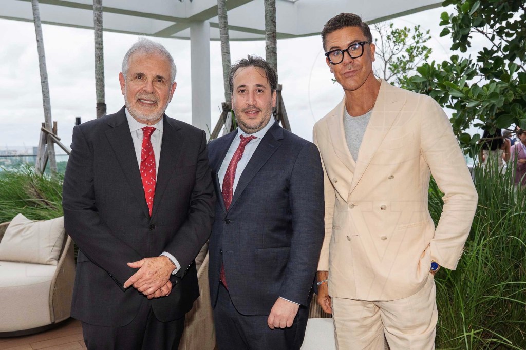 three men pose in suits