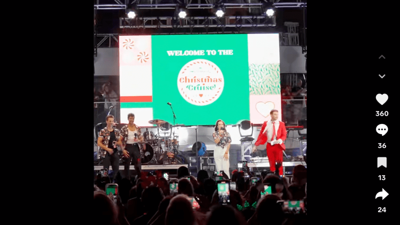 Screenshot of a TikTok video showing two hosts and two singers onstage. A backdrop on the stage reads, "Welcome to the Christmas Cruise"