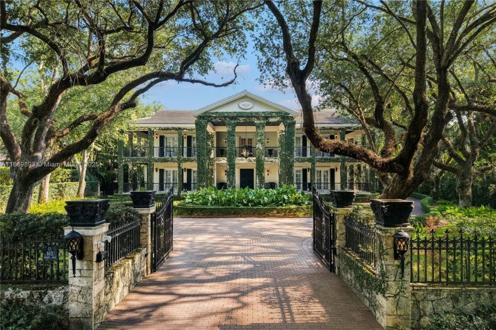 Depicted is the front driveway of a plantation-style mansion in Coral Gables.