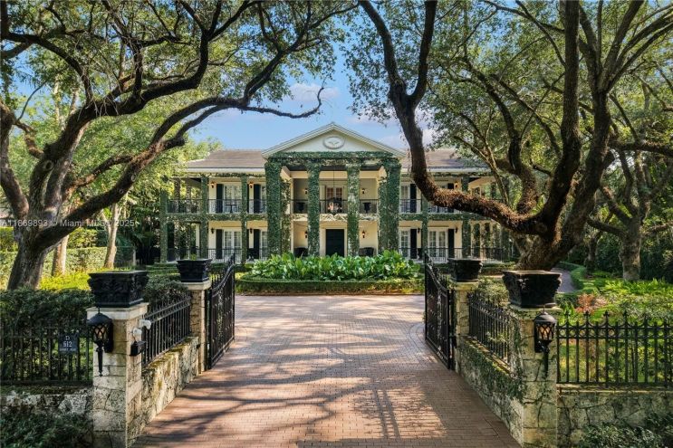Depicted is the front driveway of a plantation-style mansion in Coral Gables.