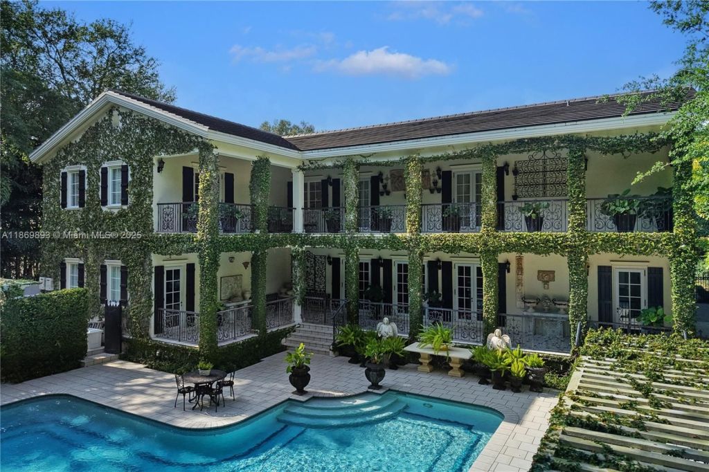 Depicted is a backyard pool surrounded by lush, manicured plants.