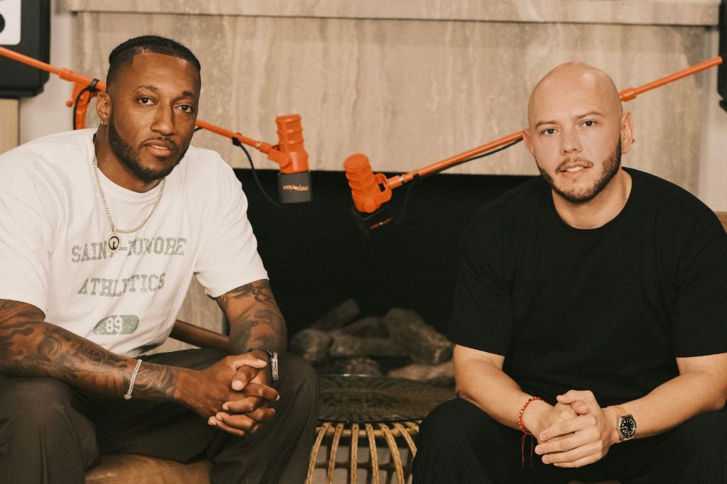 two man in front of microphones posing for the camera.