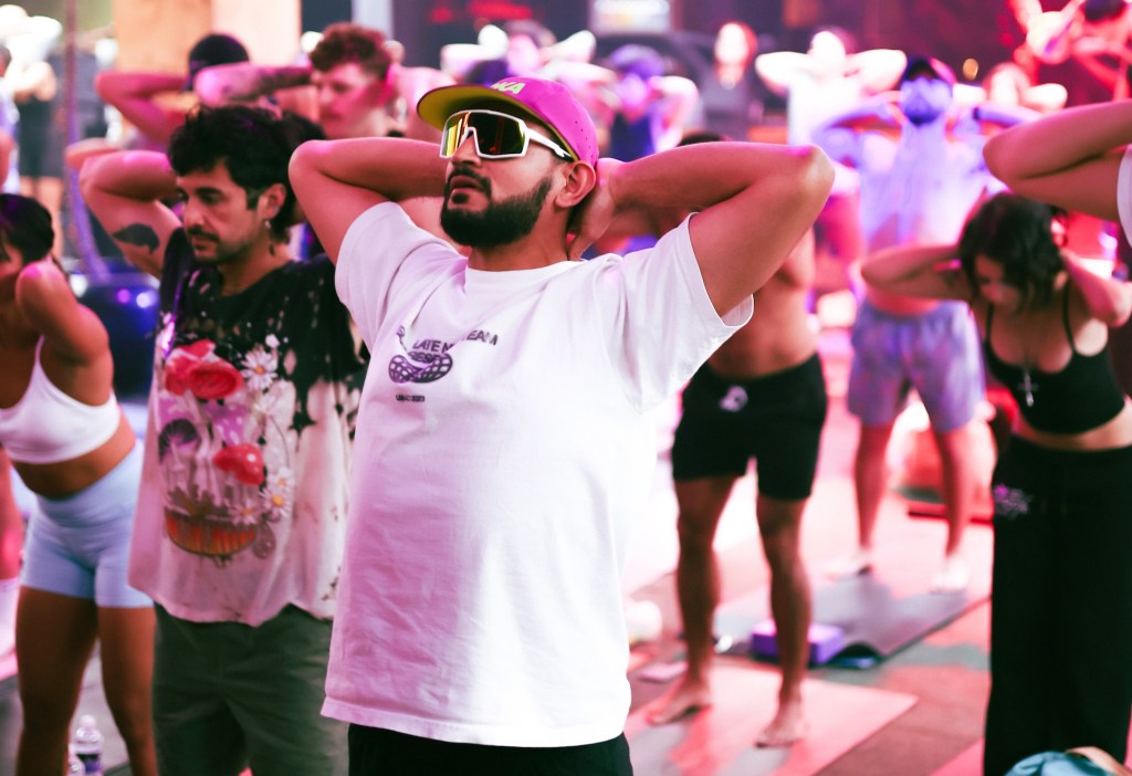 a group of people do yoga inside a nightclub