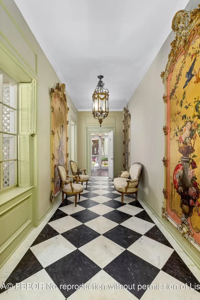 Depicted is a hallway with large paintings in ornate frames and a checkered tile floor.