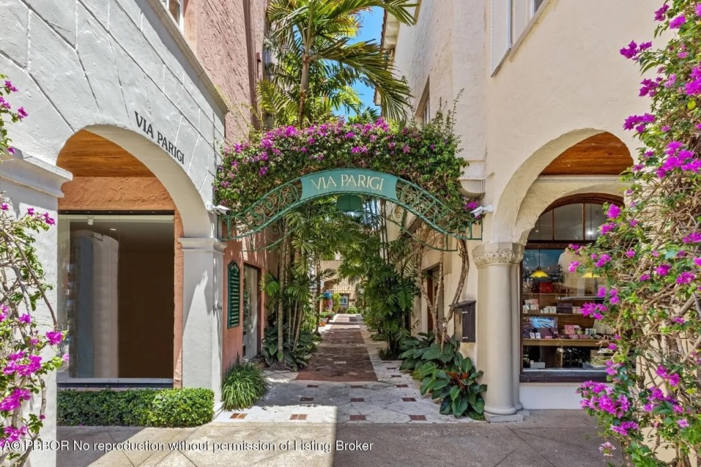 Depicted is a decorative entryway with "Via Parigi" on an elevated sign covered in purple flowers.