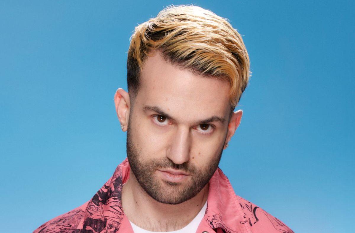 Photo of a man looking at the camera against a light blue background.