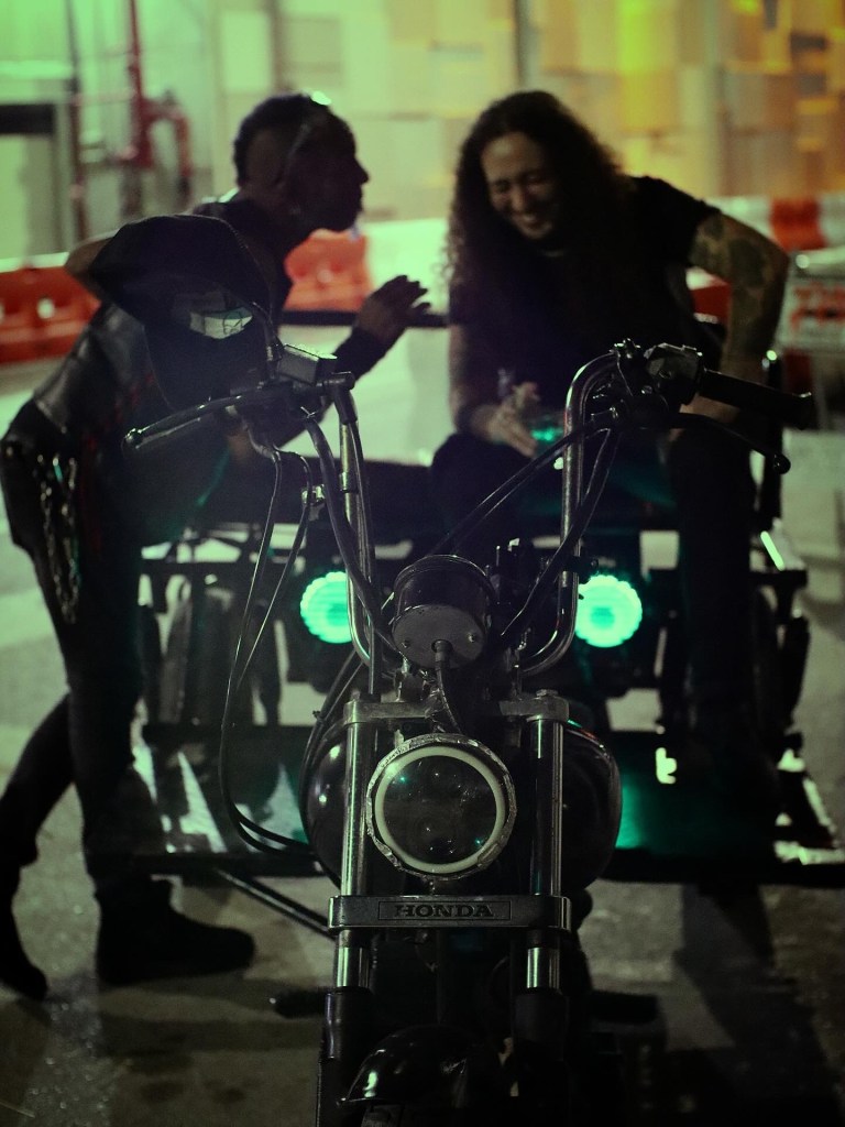 Two men talking next to motorcycles. 