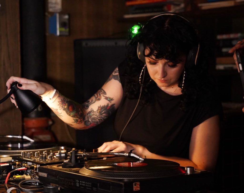 Picture of a woman playing records.