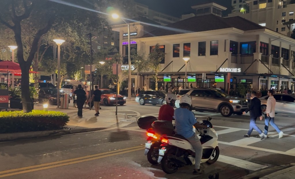 two delivery scooters at a Miami intersection at night