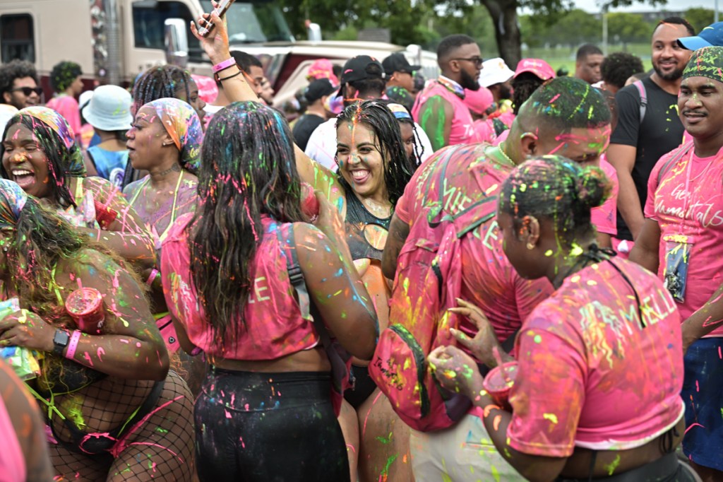 dozens of festivalgoers splattered in paint dance together