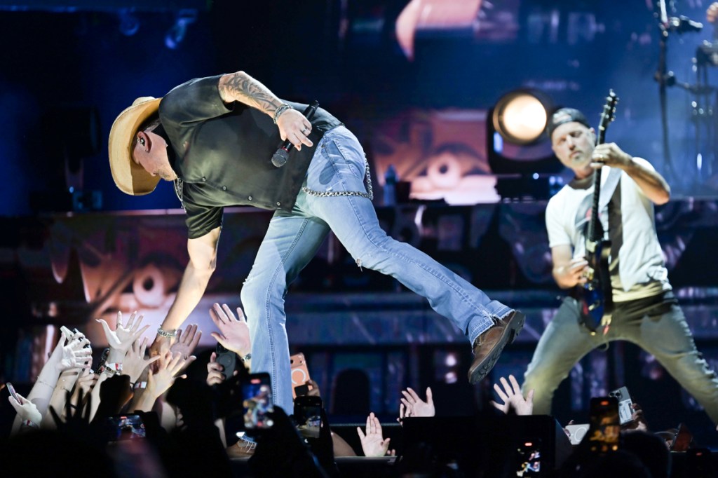 a singer on stage shaking fans hands.