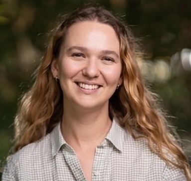 headshot of a smiling young woman with auburn hair