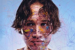 picture of a man looking at a camera covered in paint.