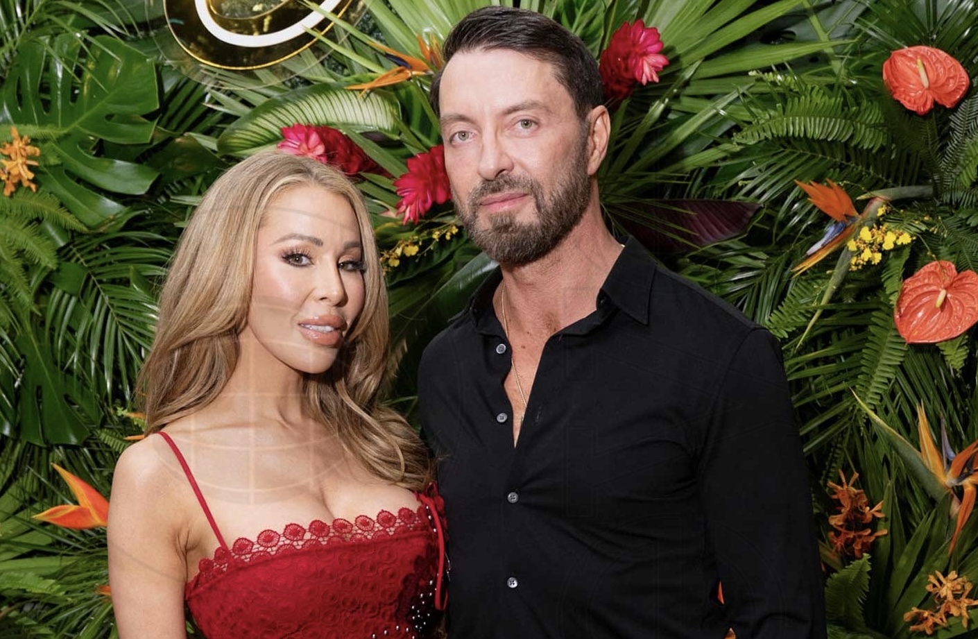 Lisa Hochstein poses in a red gown next to Jody Glidden in a black shirt and pants