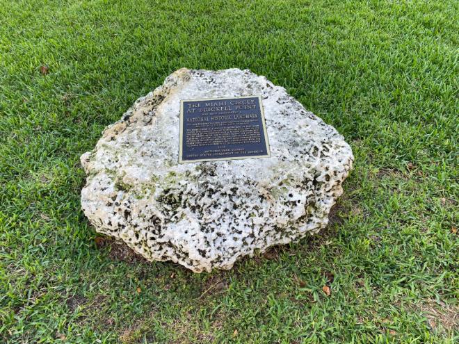 A photo of a plaque atop a rock.