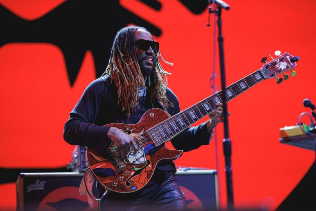 A man on stage playing bass guitar. 