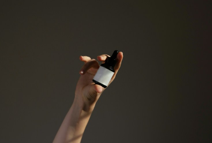 A hand holding a serum.