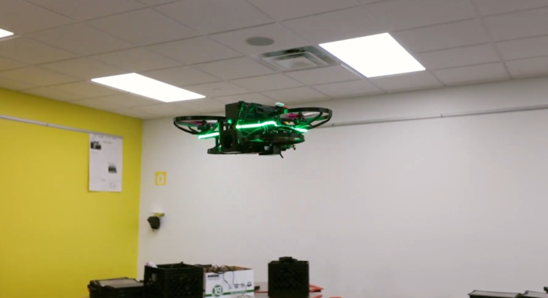 A photo of a drone flying in a classroom.
