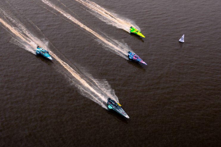 photo of an aerial view of four speed boats racing on the water