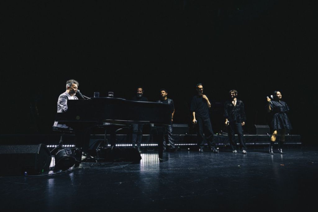 A man on stage playing the piano. 