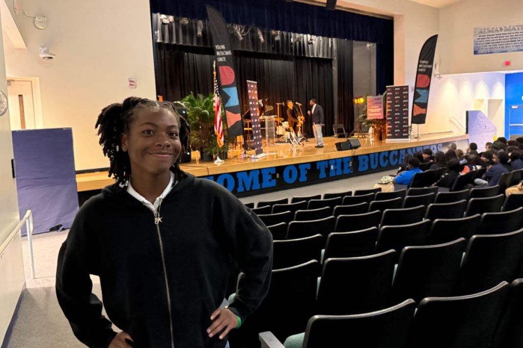 A young girl at a music class in an auditorium. 