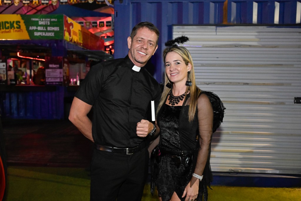 photo of a man dressed like a priest and a woman dressed like an angel in all black with a black halo