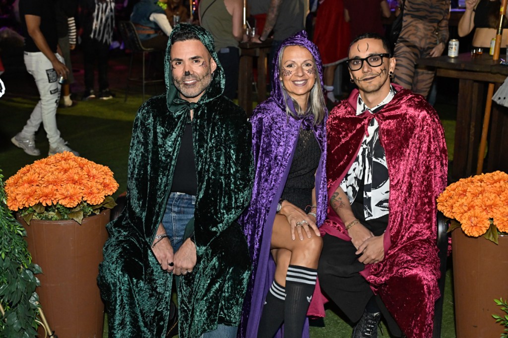 photo of three people dressed in multicolored velvet capes for Halloween