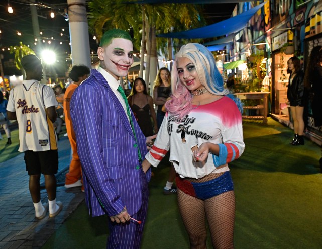Photo of two people in costume: A man dressed like the Joker and a woman dressed as Harley Quinn from Suicide Squad