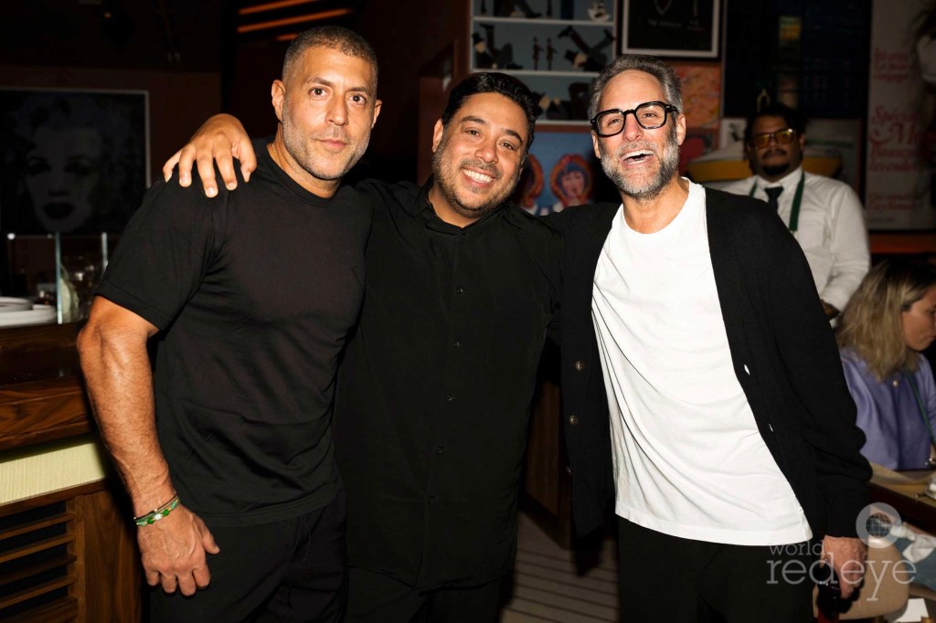 photo of three men posing together at a party
