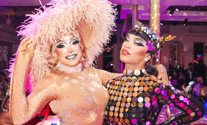photo of two drag queens embracing inside a club
