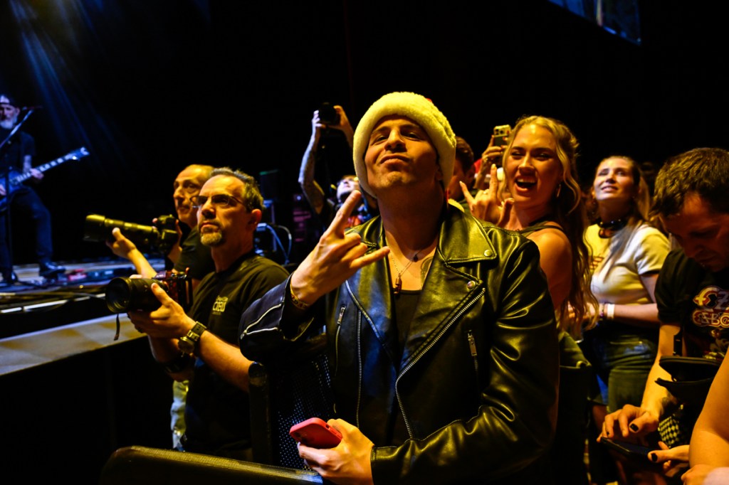 Photo of fans at a rock show wearing leather jackets and Christmas hats. 