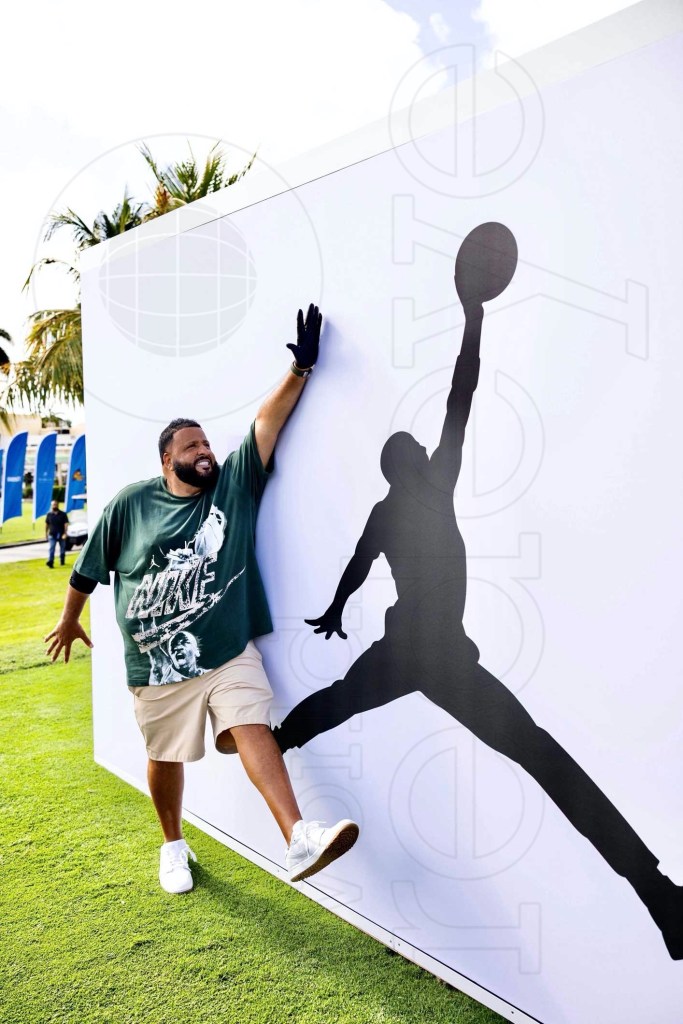 photo of DJ Khaled imitating the silhouette of a dunking basketball player on a white wall