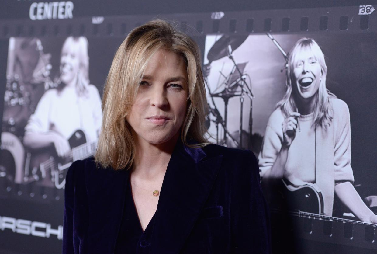 Photo of a blonde woman looking at the camera wearing a black suit.