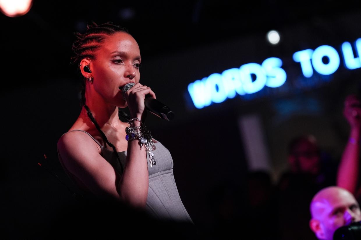 Photo of a woman singing with a microphone on stage