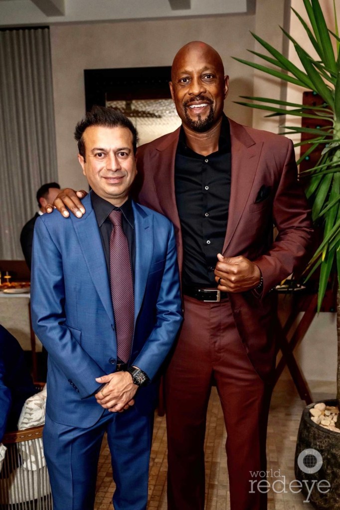 photo of Kamal Hotchandani and Alonzo Mourning posing together in suits