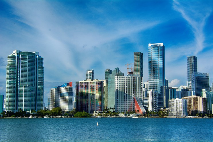 hi-rise condos and skyscrapers from Miami's skyline stand behind a foreground of blue water