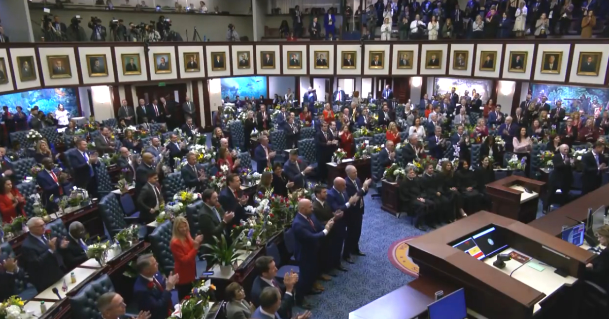 State legislators applauding and standing in the Florida Representatives chambers