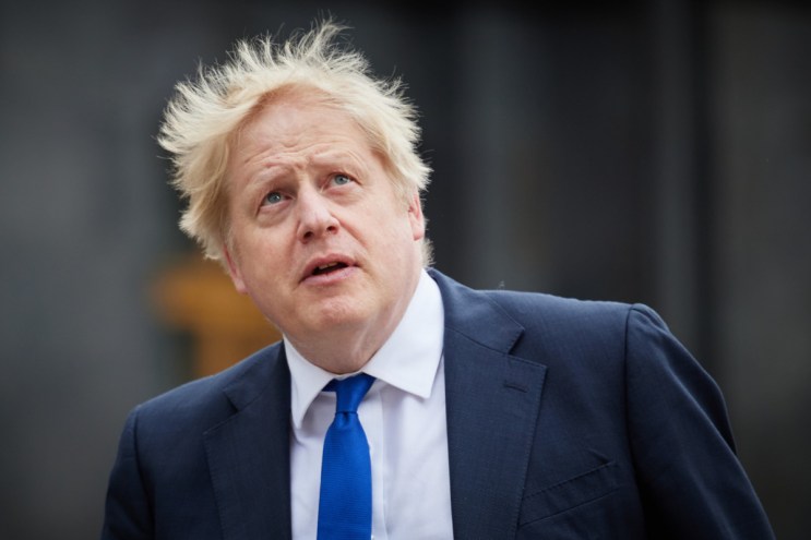 A white man with tousled hair looking up to the sky.