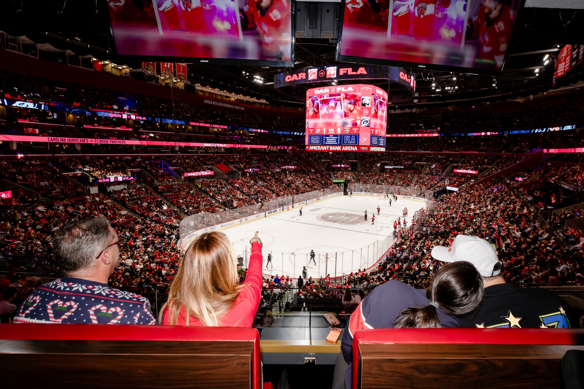 photo of a crowd looking at a hockey game from an arena suite
