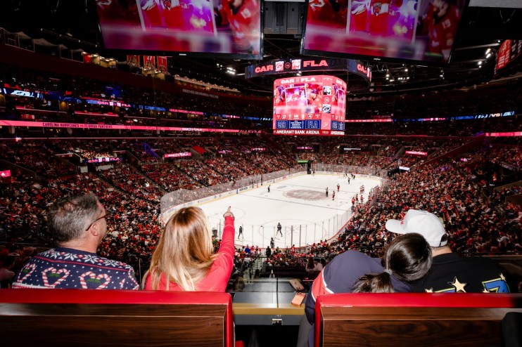 photo of a crowd looking at a hockey game from an arena suite