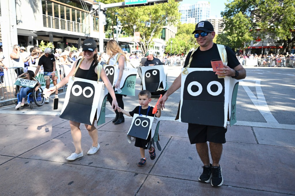 photo of a family at a parade wearing DIY costumes of food delivery robots