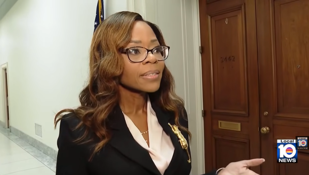 A photo of a woman in glasses and a suit.