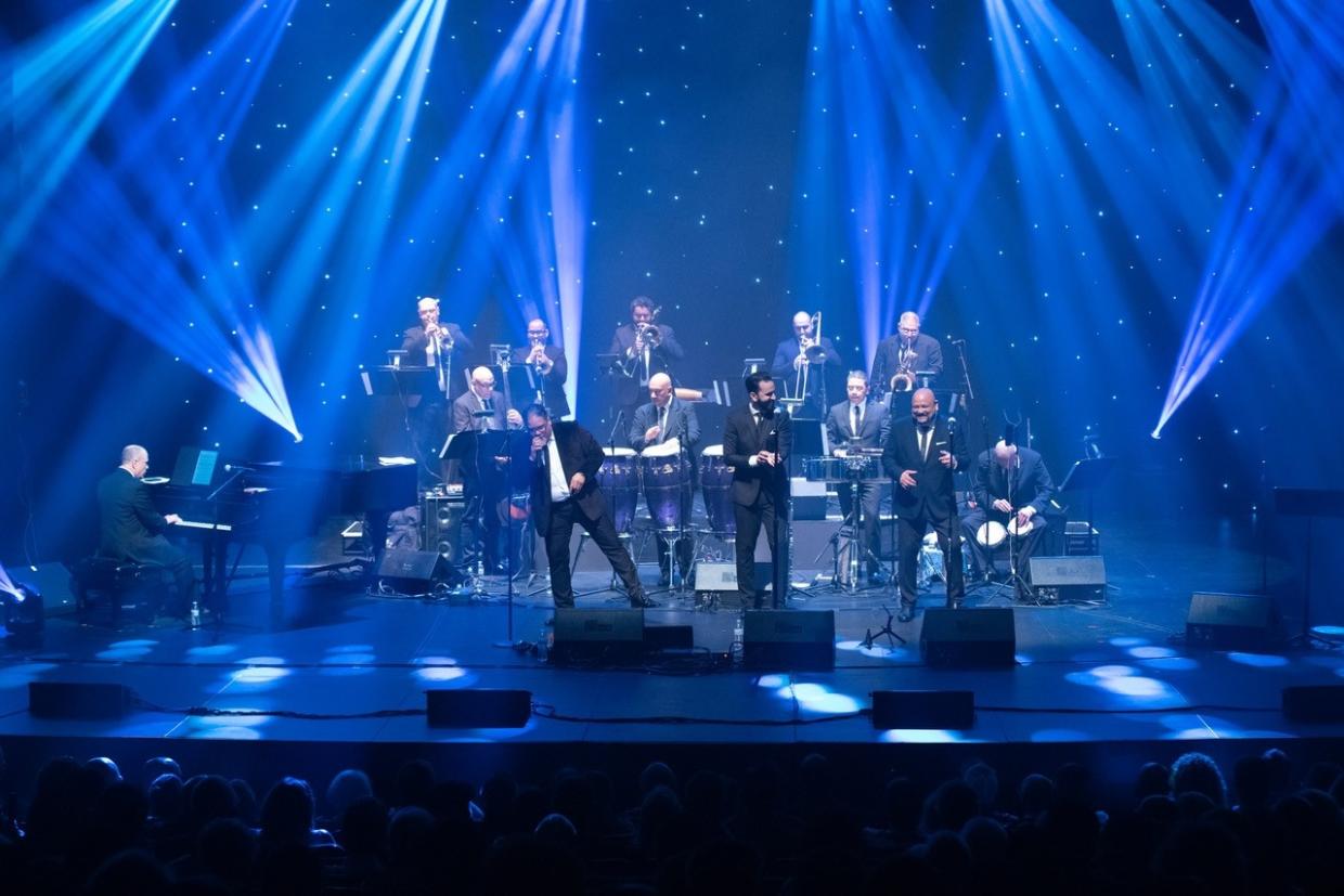 An orchestra on stage under blue lights