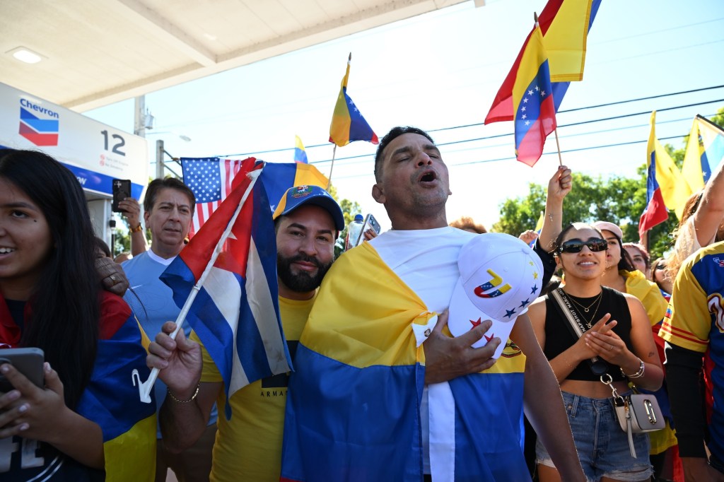 photo of protesters wearing clothes with the Venezuelan flag and waving Venezuelan flags.