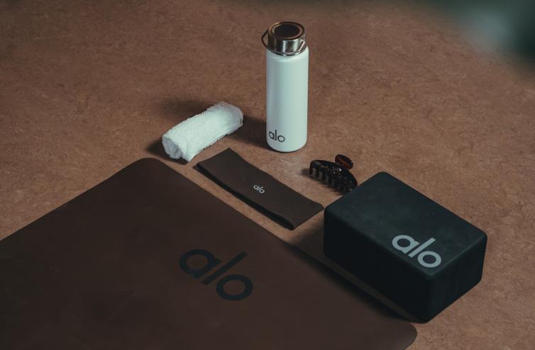 photo of a yoga mat, headband, yoga block, and water bottle with the brand name "Alo"