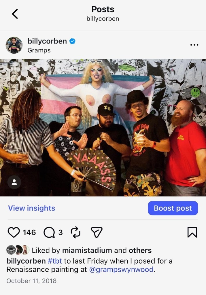 Screenshot of an Instagram post by user @billycorben showing five men posing with a drag queen in front of a trans pride flag. The caption reads, "#tbt to last Friday when I posed for a Renaissance painting at @grampswynwood"